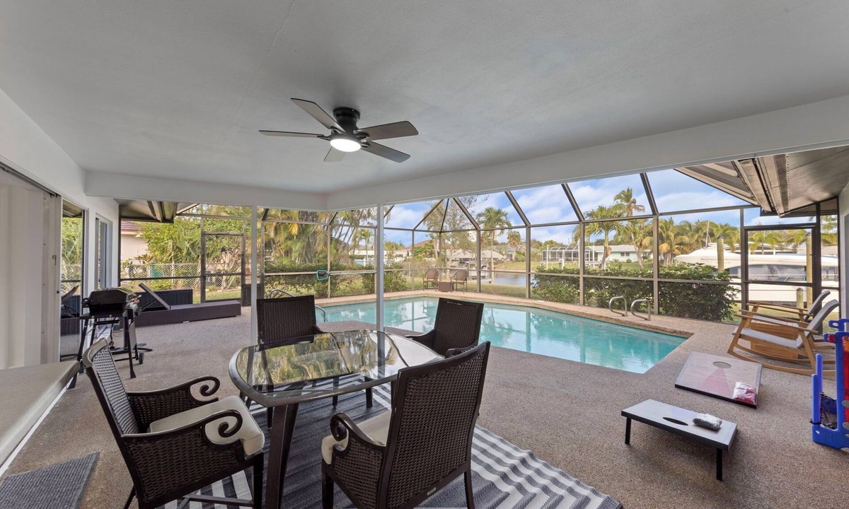 Town and River House | Modern riverfront home 4 br & 3 bath with stunning canal water views, private heated pool, garage & private dock access great for fishing, 4 bikes to explore, and minutes to Sanibel, Captiva, and local beaches.