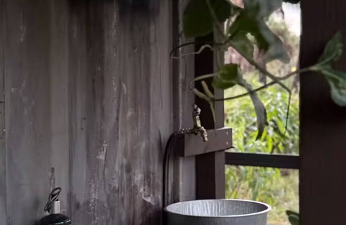 Rural Estates Cabin | Luxury off-grid passionfruit covered shipping container immersed in nature.