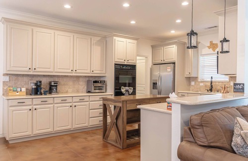 Westminster House | Modern country comfort in this 4-bedroom Anna retreat near McKinney. Sleeps 12 with open layout, full kitchen, foosball, and covered patio with BBQ. Rustic Texas charm with modern amenities — perfect for family or group getaways.