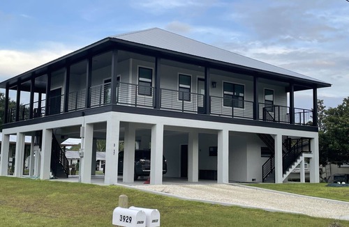Indian Waters House | New Stilt Home on quiet canal with wrap around porch.