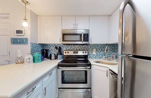 Cape Caneveral Beach Gardens Condo | Pristine condo with shared pool, hot tub, and balcony with partial ocean view