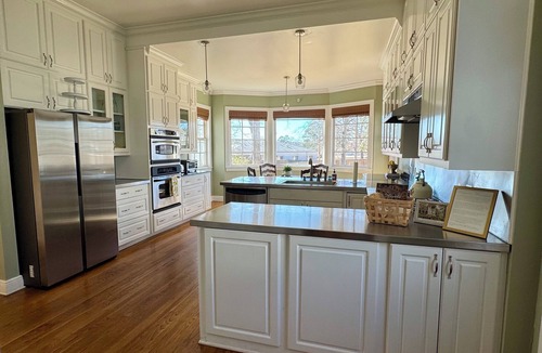 Magnolia House | Relax sitting on wrap around porch in this Historic Mansion