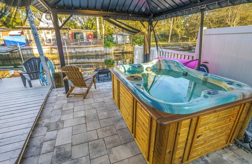 Weeki Wachee Gardens House | River home with huge arcade, hot tub, kayaks, mini golf course, 80in TV