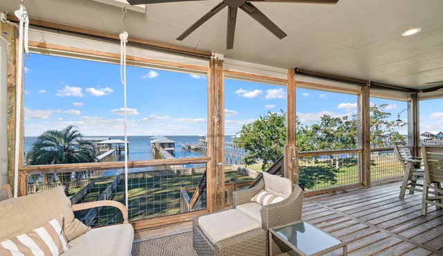 A charming waterfront getaway on Mobile Bay featuring a private pier, cozy outdoor spaces, and beautiful bay views.