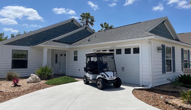 Sunlit open-concept retreat w/granite kitchen island, golf cart & dual lanai.